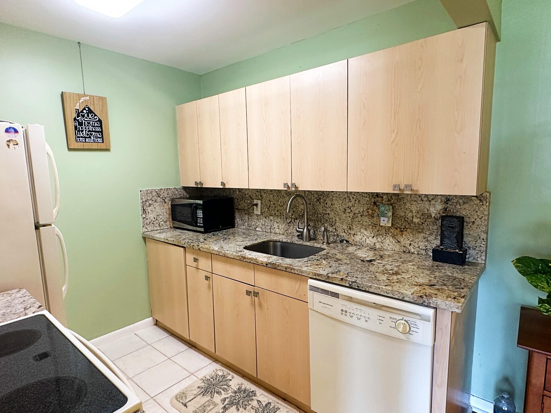 1094 Cornwall East Boca Raton, FL 33434 - Photo 3 of 35 a kitchen with stainless steel appliances granite countertop a sink a stove and a microwave