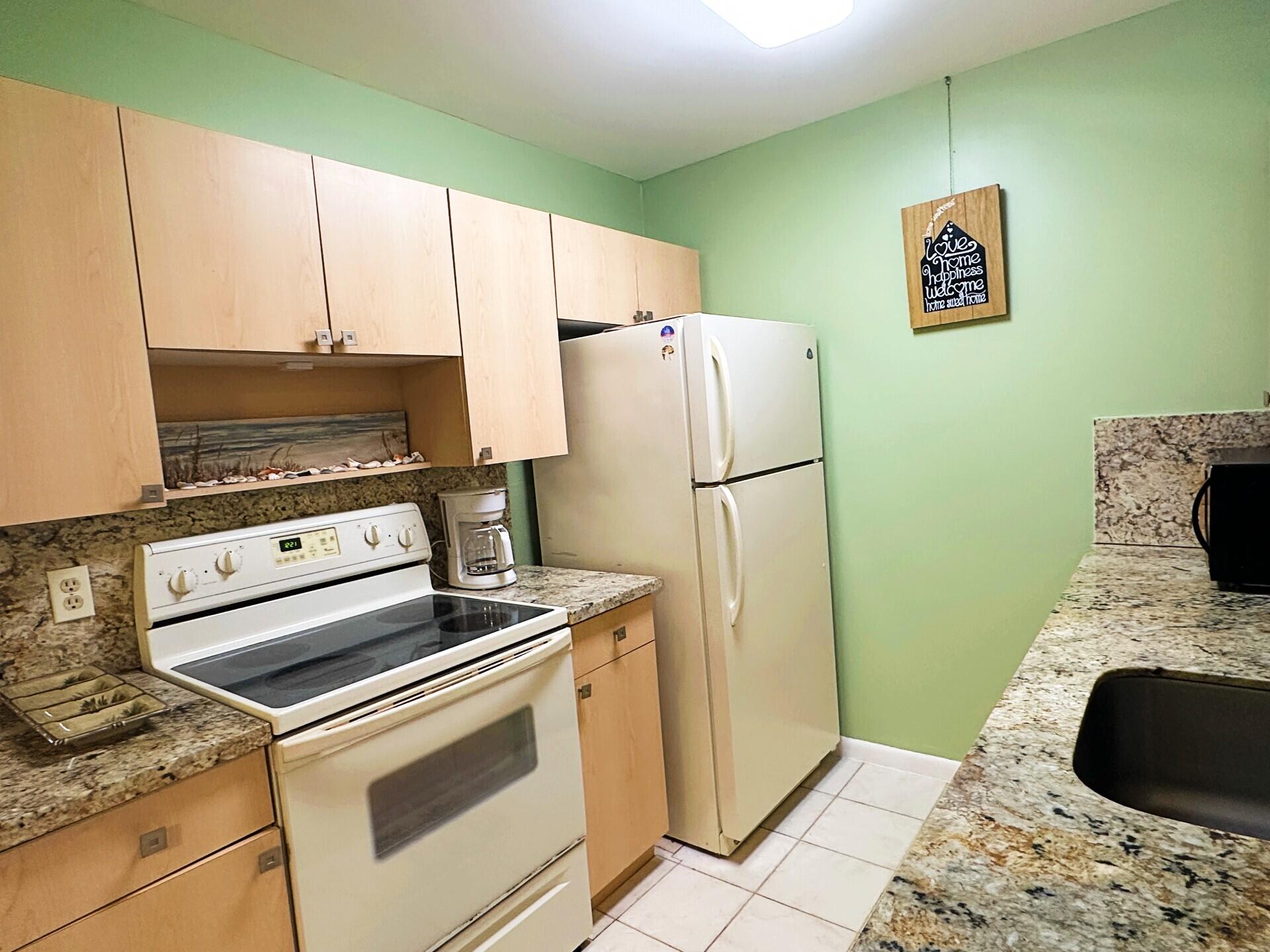 1094 Cornwall East Boca Raton, FL 33434 - Photo 4 of 35 a kitchen with a refrigerator and a stove top oven
