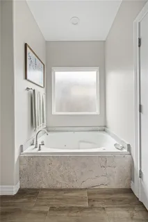 a bathroom with bathtub and window