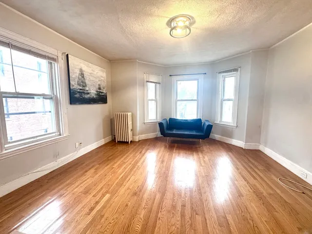 a living room with a hard wood floor and a window