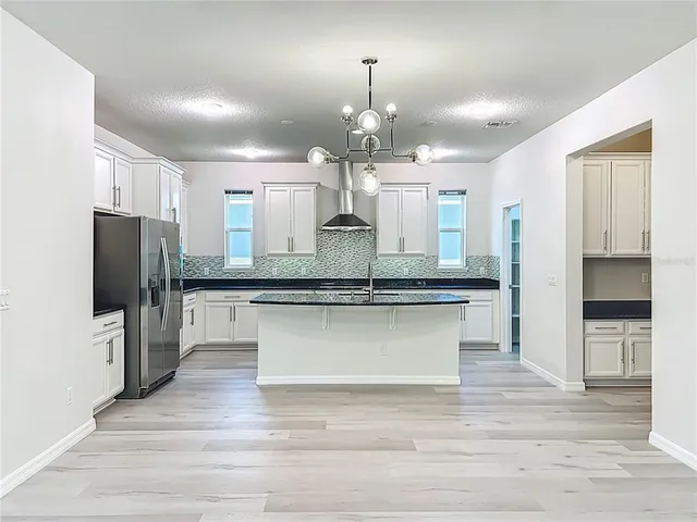 a large kitchen with stainless steel appliances kitchen island granite countertop a large counter top and a stove top oven