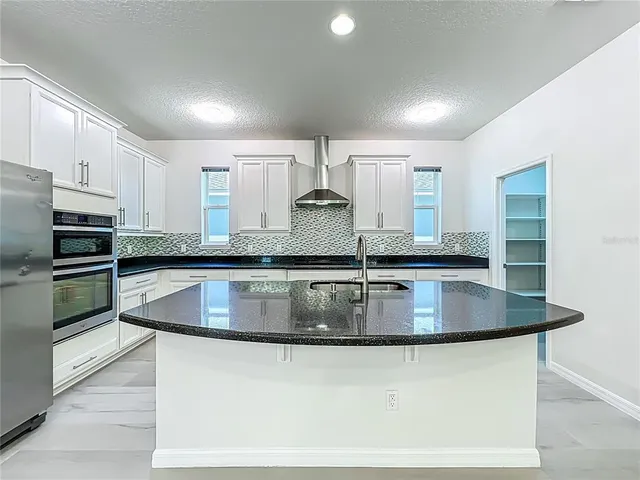a bathroom with a granite countertop sink a toilet a mirror and shower