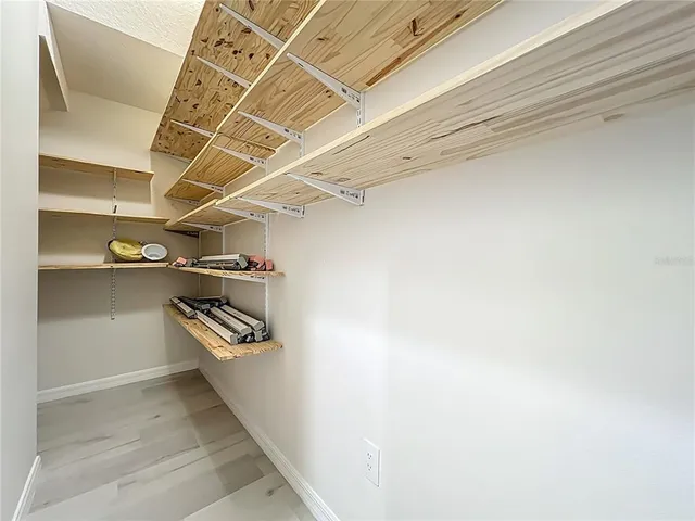 a view of walk in closet with empty racks