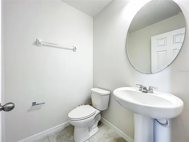 a spacious bathroom with a granite countertop sink a toilet a mirror and shower