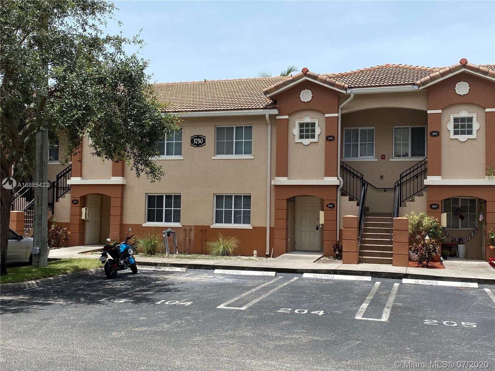 3750 North Jog Road, Unit 105 West Palm Beach, FL 33411 - Photo 3 of 8 a front view of a house with a yard