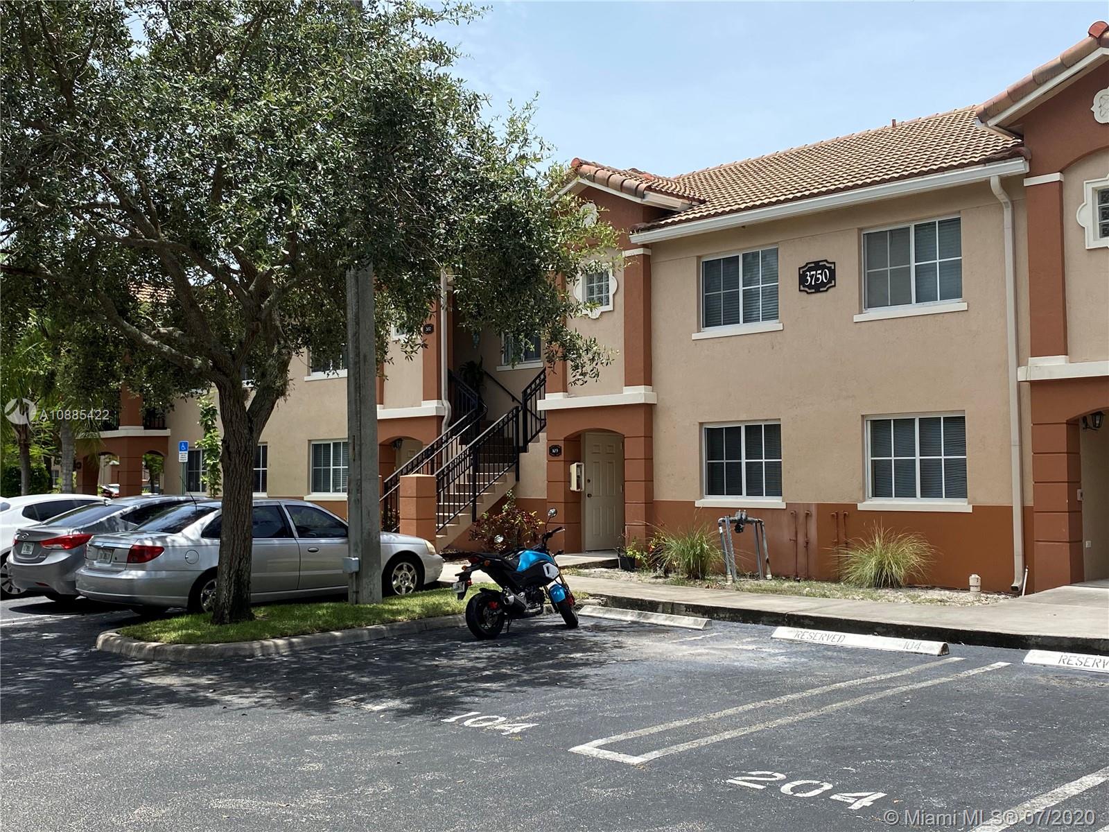3750 North Jog Road, Unit 105 West Palm Beach, FL 33411 - Photo 4 of 8 a street view with couple of cars parked in front of house