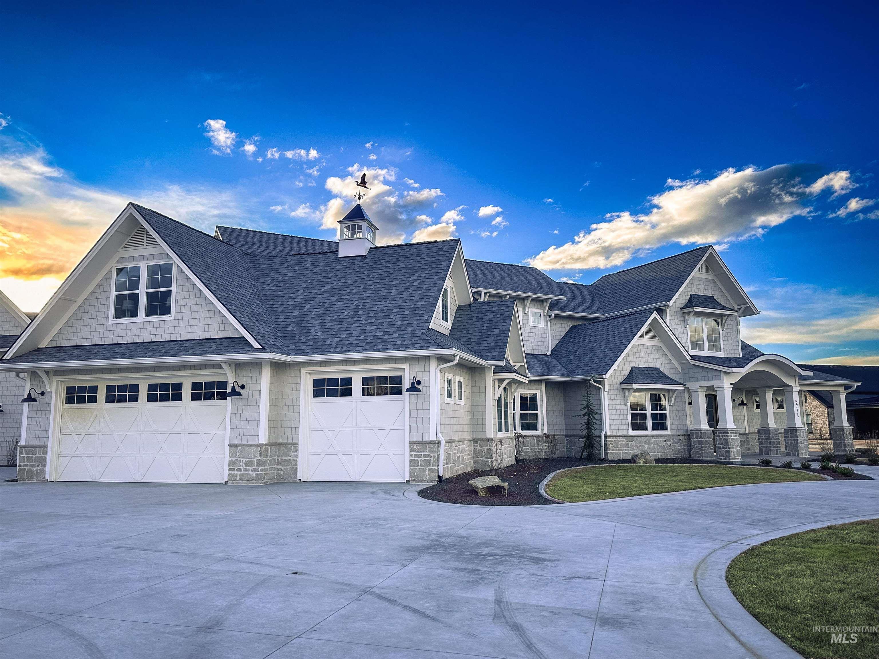 7448 North Cavea Lane Meridian, ID 83646 - Photo 2 of 40 View of front of home with concrete driveway, stone siding, a shingled roof, and a front yard