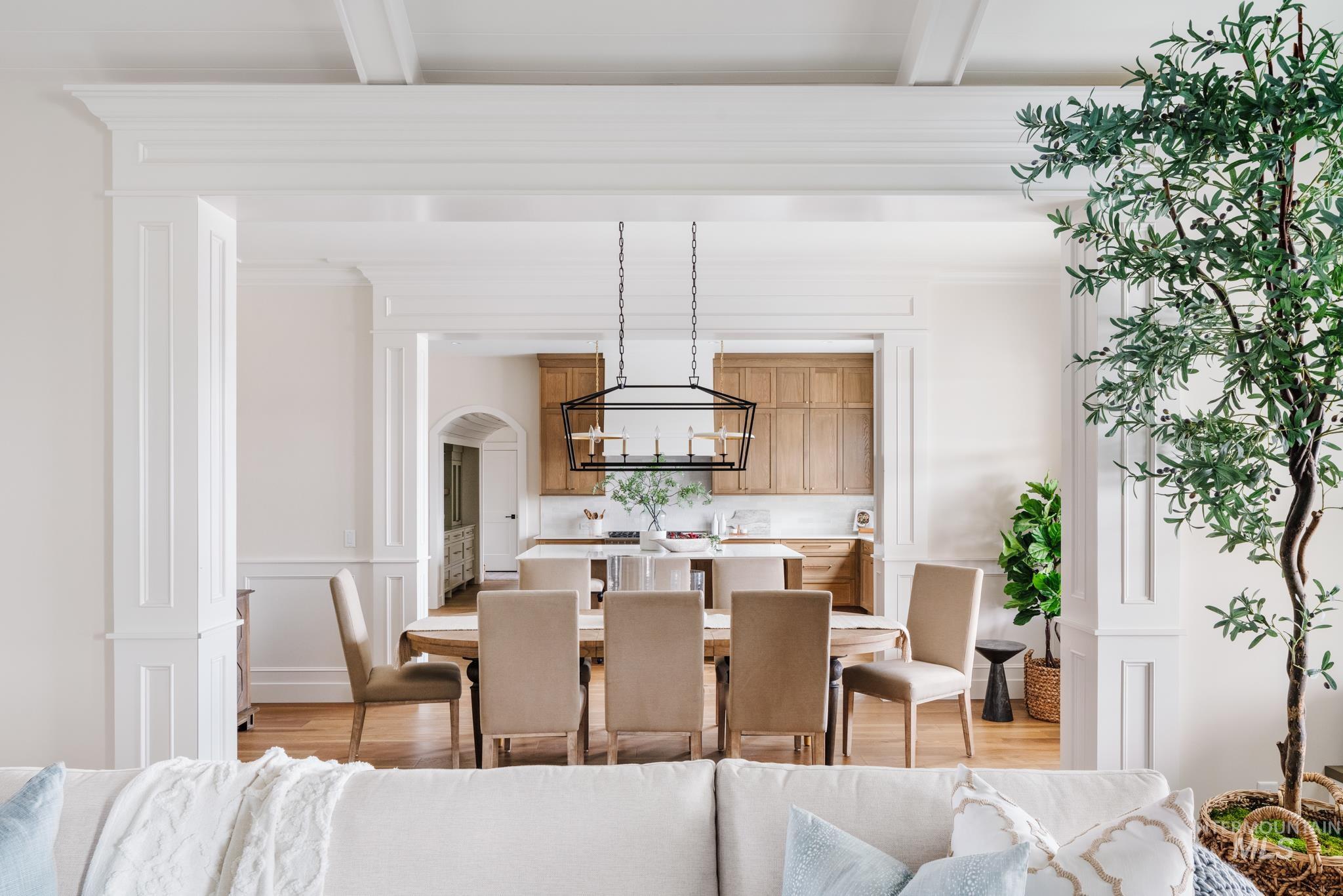 7448 North Cavea Lane Meridian, ID 83646 - Photo 35 of 40 Dining room with light wood-type flooring, arched walkways, crown molding, and a decorative wall