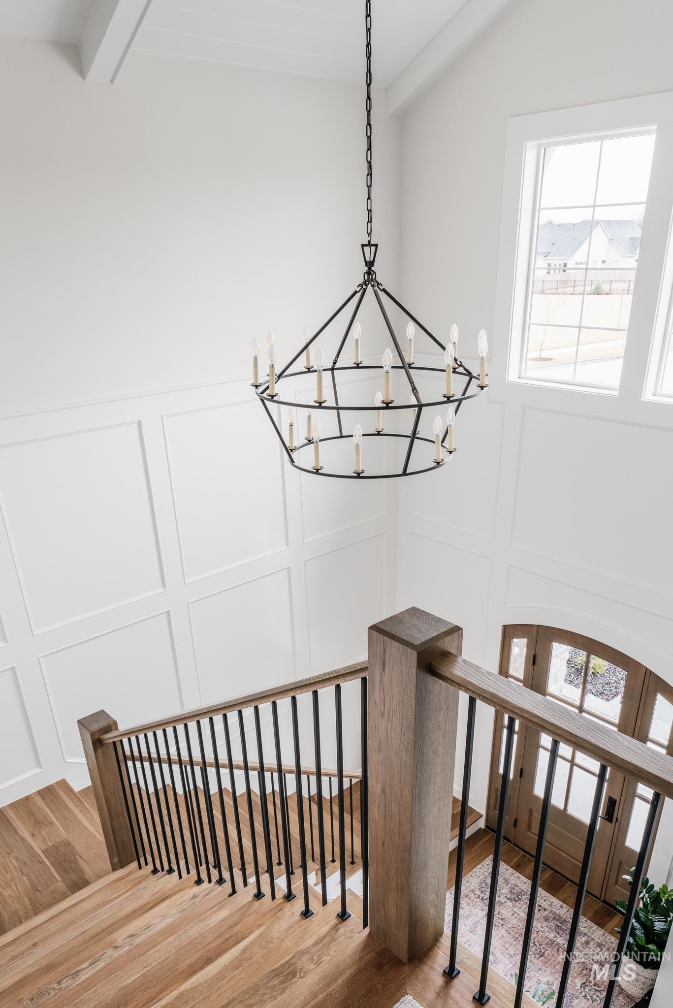 7448 North Cavea Lane Meridian, ID 83646 - Photo 36 of 40 Stairs with wood finished floors, a chandelier, a decorative wall, and beam ceiling