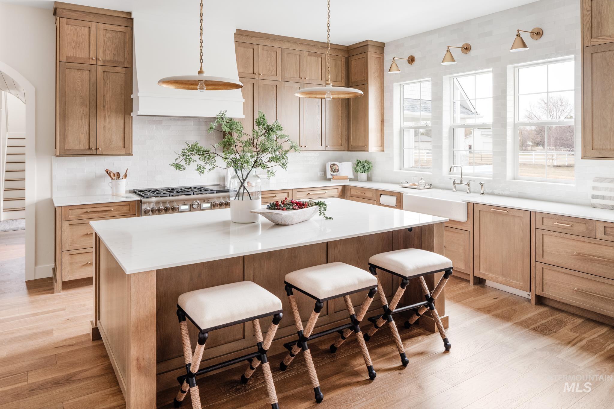7448 North Cavea Lane Meridian, ID 83646 - Photo 5 of 40 Kitchen featuring backsplash, a kitchen bar, premium range hood, and a kitchen island