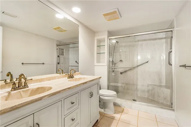 a bathroom with a granite countertop sink a toilet and shower