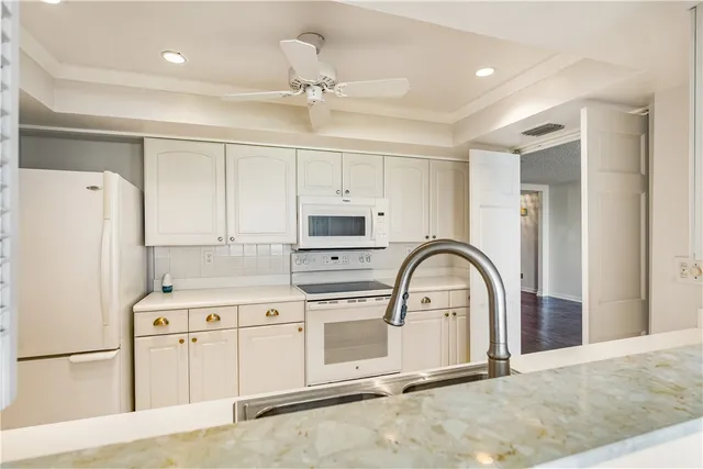 a spacious en suite bathroom with a granite countertop sink and a mirror