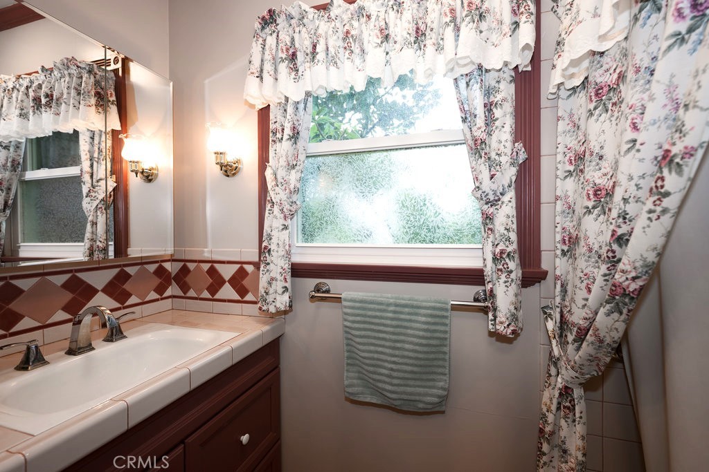 8621 Winnetka Avenue Winnetka, CA 91306 - Photo 20 of 25 a bathroom with a granite countertop sink and a mirror
