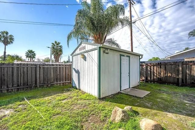 a backyard of a house with plants and wooden fence