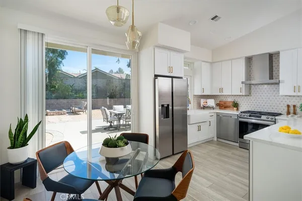 a kitchen with sink a refrigerator and chairs
