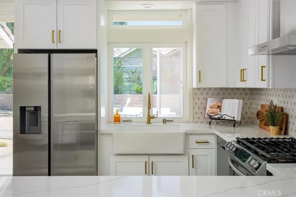 a kitchen with stainless steel appliances granite countertop a refrigerator stove and sink