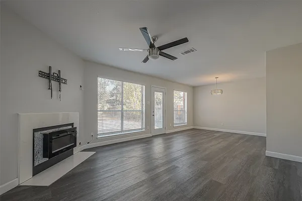 a view of an empty room with a fireplace and a window
