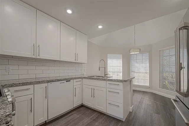 a kitchen with a sink window and cabinets