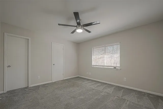 a view of a livingroom with a ceiling fan and window