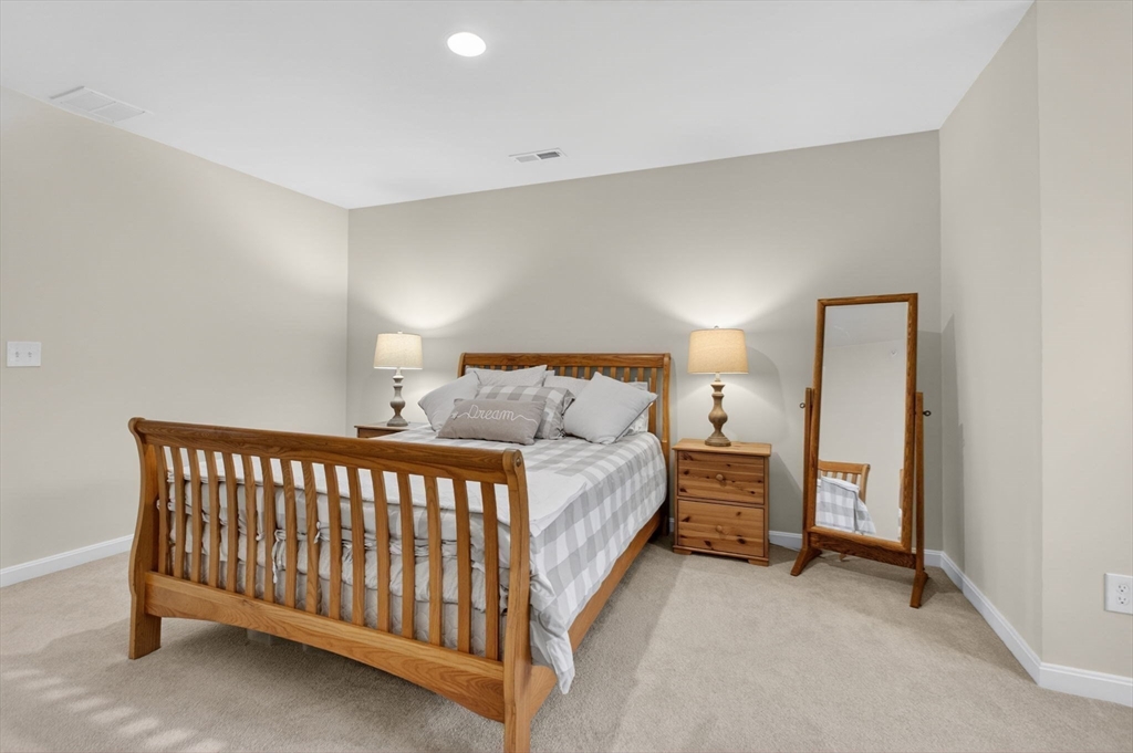 87 Shannon Way, Unit 86 Upton, MA 01568 - Photo 26 of 36 a bed room with a bed and a lamp
