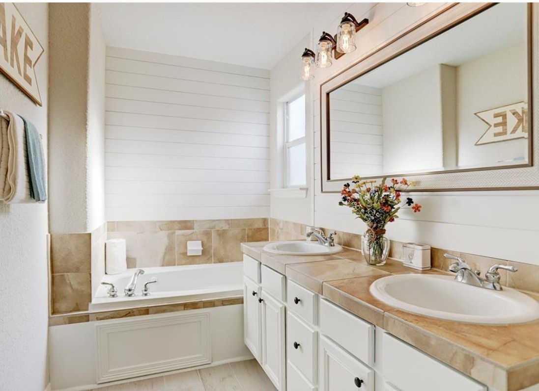 277 Capetown Conroe, TX 77356 - Photo 7 of 10 Spa-like primary bathroom featuring dual vanities, a soaking tub, and stylish finishes designed for comfort and relaxation.