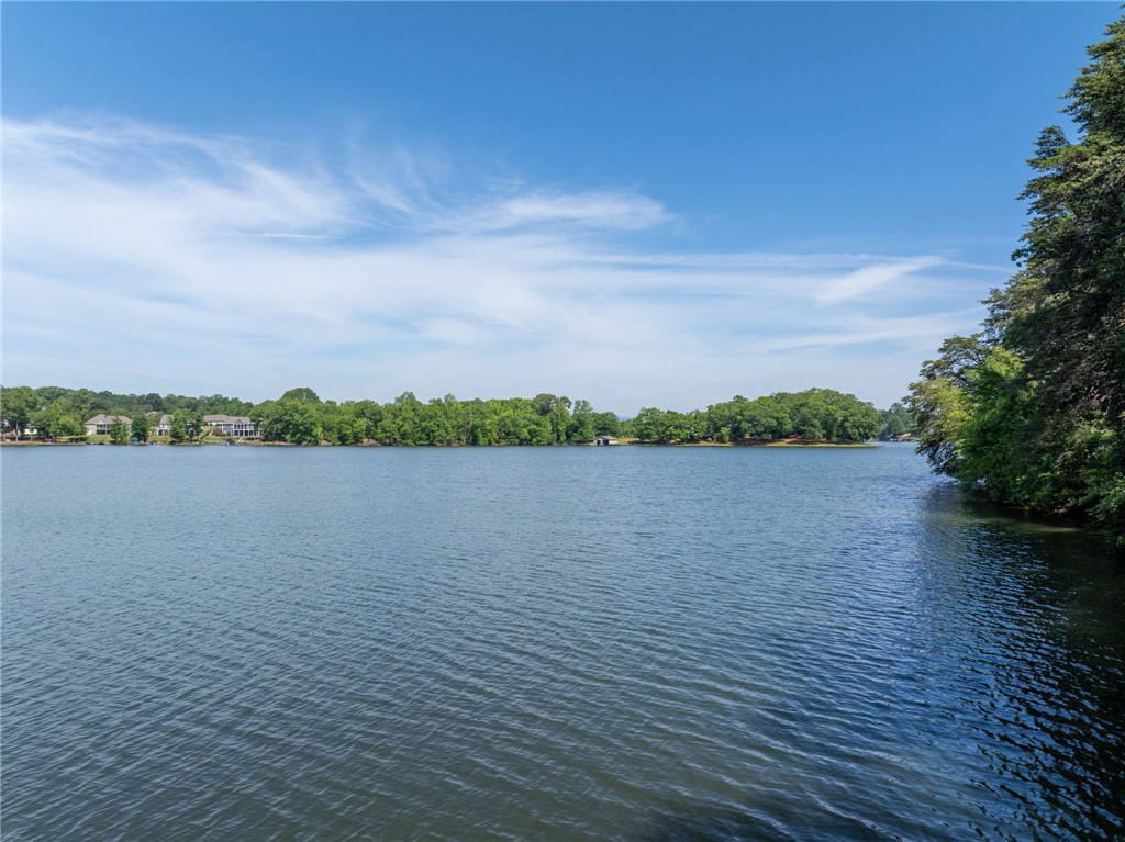 0 Ben Hurt Road Lyman, SC 29365 - Photo 14 of 21 Vast, tranquil waters stretch towards a verdant shoreline under an expansive blue sky.