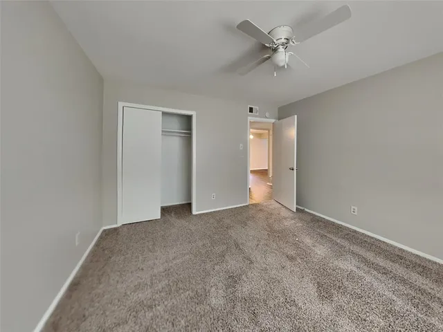 an empty room with a ceiling fan and a window