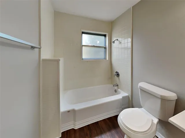 a white toilet and tub sitting next to a bathroom sink