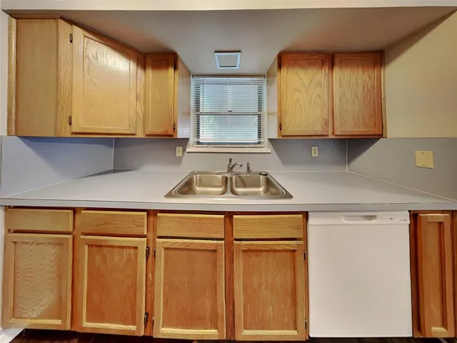a kitchen with stainless steel appliances granite countertop white cabinets and a sink