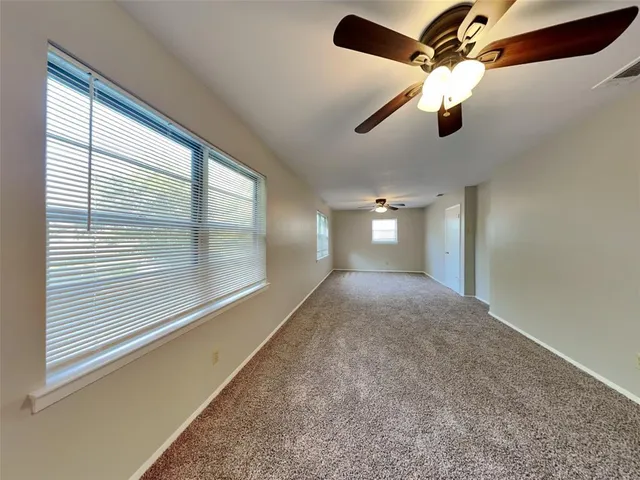 a view of a livingroom with a ceiling fan and window