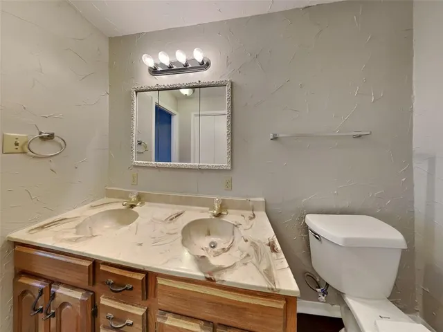 a bathroom with a sink a toilet and a mirror