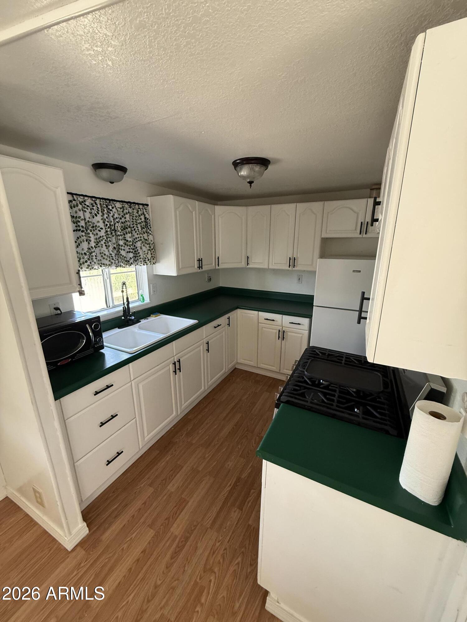 9501 East Broadway Road, Unit 48 Mesa, AZ 85208 - Photo 4 of 12 a kitchen with granite countertop a sink a stove and cabinets