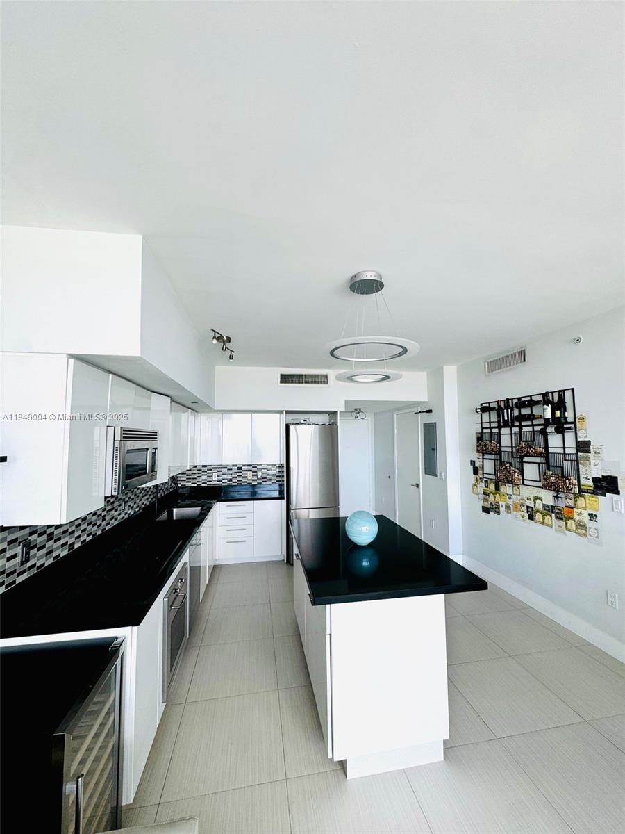 92 Southwest 3rd Street, Unit 3608 Miami, FL 33130 - Photo 5 of 24 a kitchen with kitchen island a counter top space a sink and cabinets