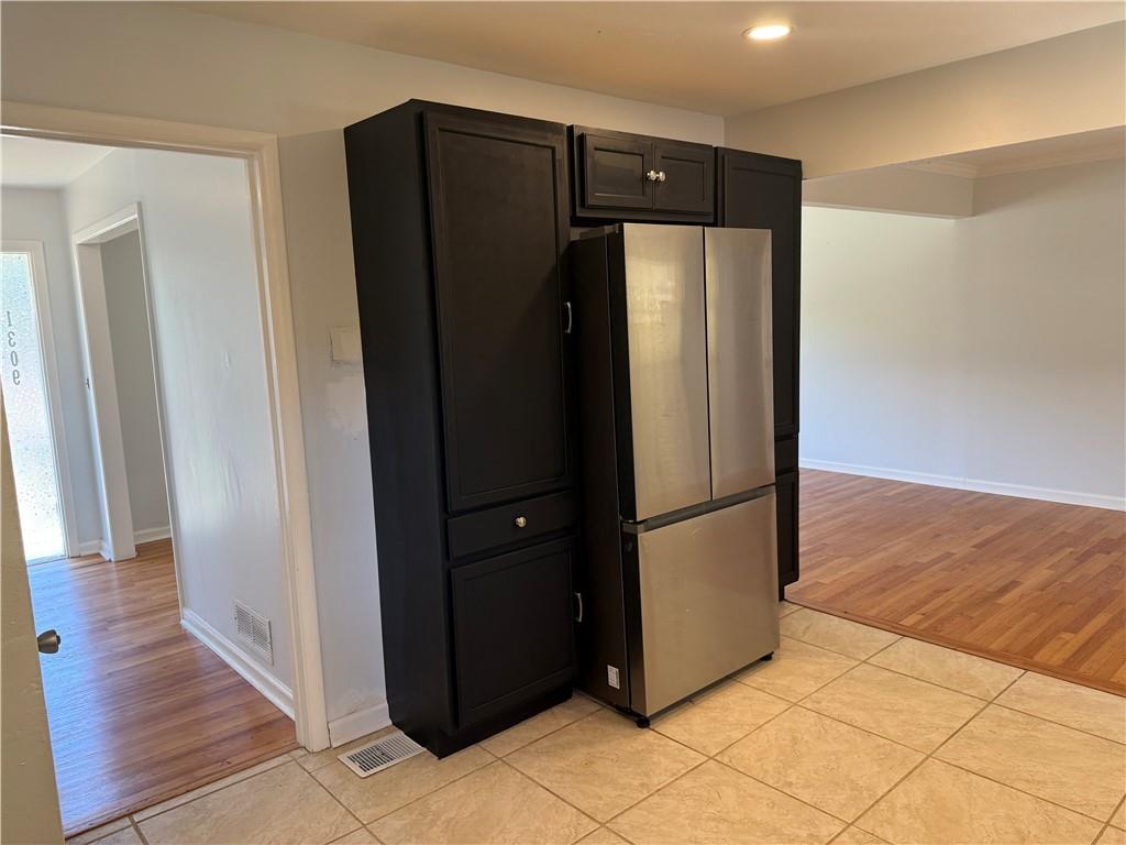 1309 Weston Drive Decatur, GA 30032 - Photo 29 of 35 a view of a refrigerator in kitchen and an empty room in wooden floor