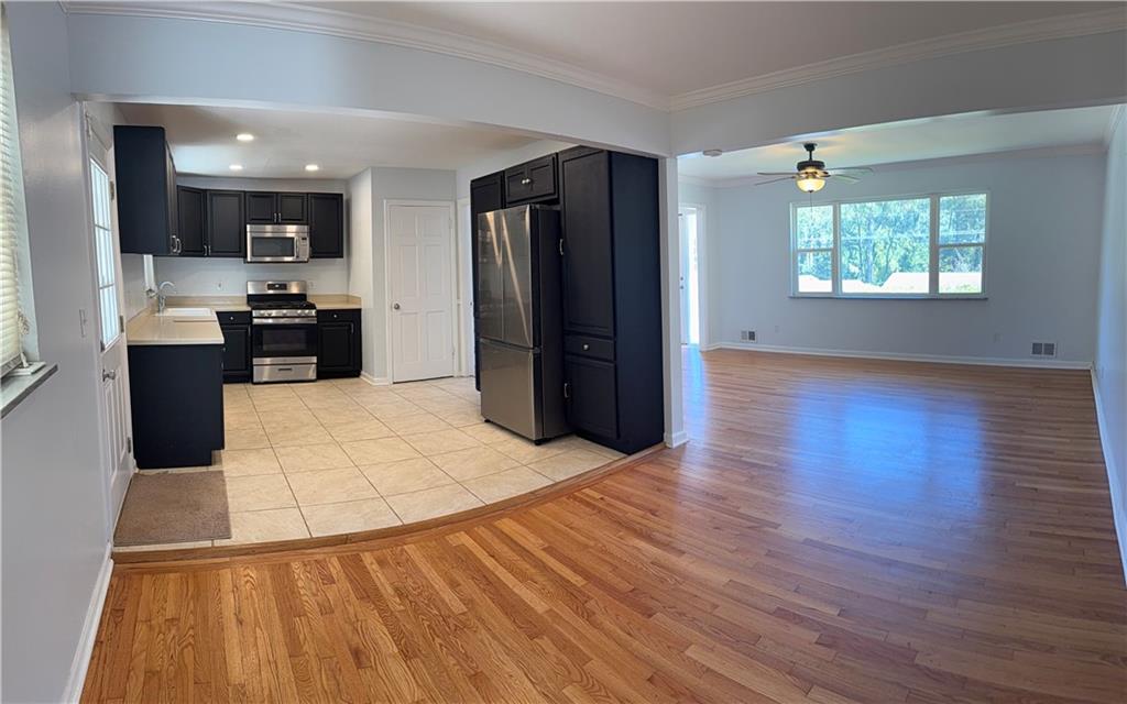 1309 Weston Drive Decatur, GA 30032 - Photo 31 of 35 an empty room with wooden floor and kitchen view