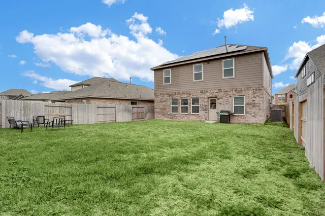 a view of a house with backyard and a garden
