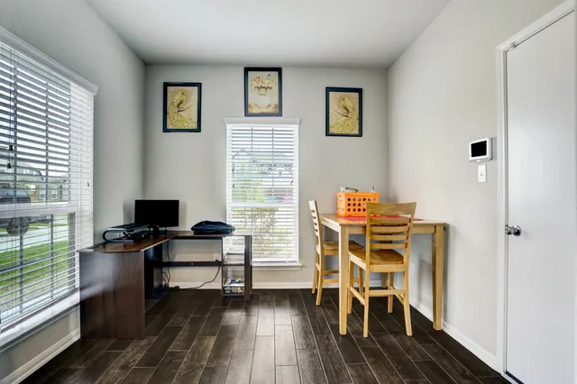 a view of a workspace with furniture and a window