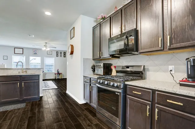a kitchen with stainless steel appliances granite countertop a stove a sink and a refrigerator