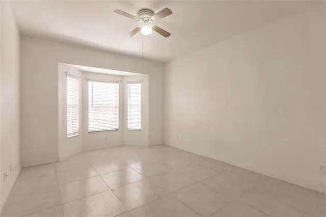 an empty room with an entryway and fan