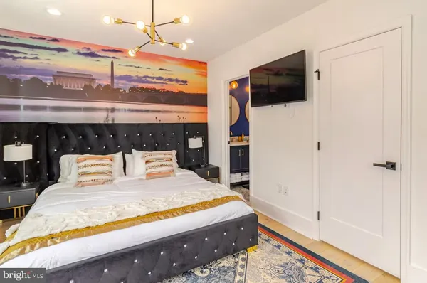 a bedroom with a bed a flat screen tv and cabinets