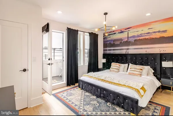 a large bedroom with a bed and wooden floor