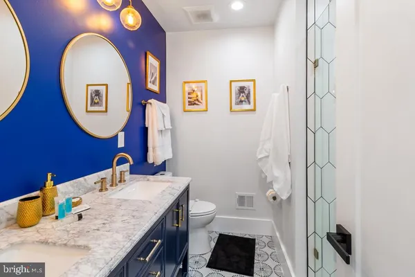 a bathroom with a granite countertop sink mirror and a shower