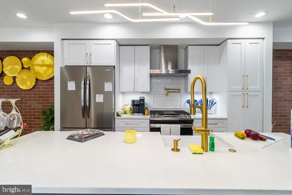 a kitchen with stainless steel appliances a refrigerator and a wooden floors