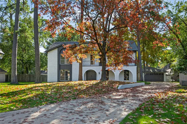 a view of a yard with yellow house in the background