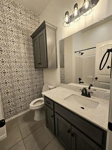 a bathroom with a sink a toilet and mirror