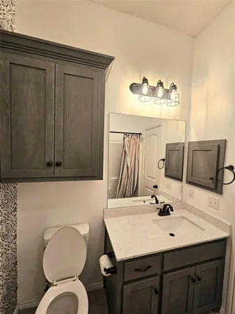 a bathroom with a sink vanity mirror and toilet