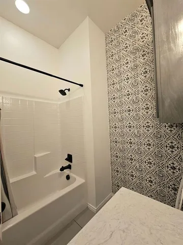 a bathroom with a bathtub and shower