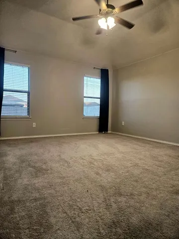 an empty room with a ceiling fan and window