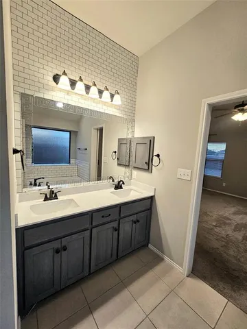 a spacious bathroom with a double vanity sink and a mirror