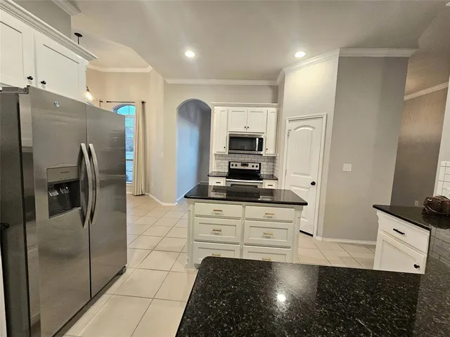 a kitchen with stainless steel appliances granite countertop a refrigerator and a stove